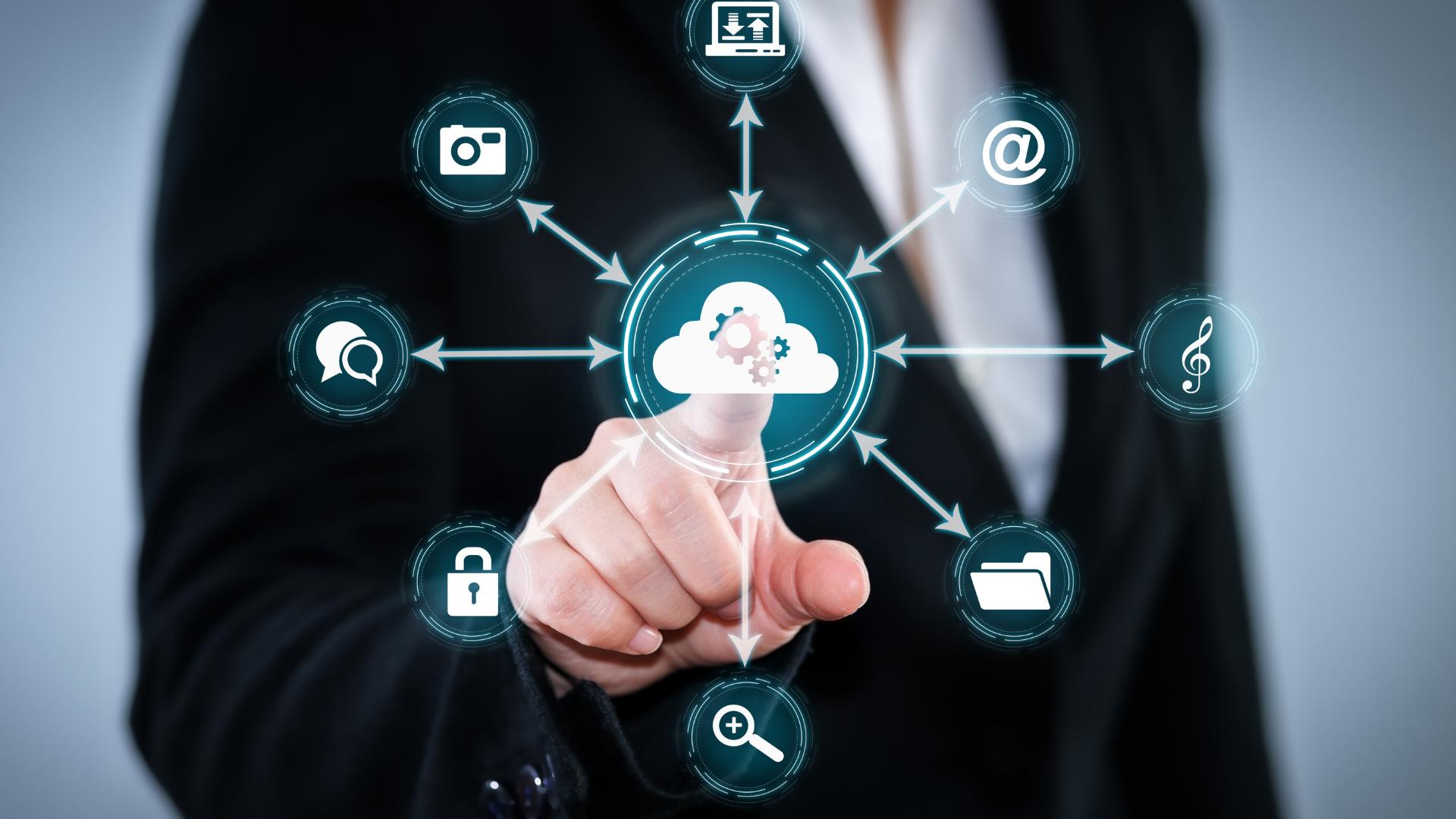 A person in a suit touches a virtual screen displaying a cloud icon linked to various digital service icons, representing how managed service providers (MSPs) enable seamless cloud computing and data integration.