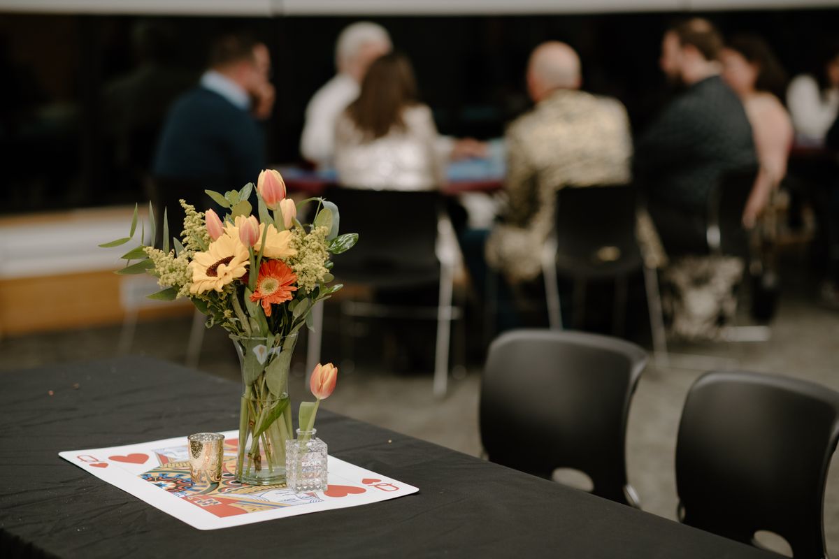 Casino night decorations with playing card centerpieces and flowers