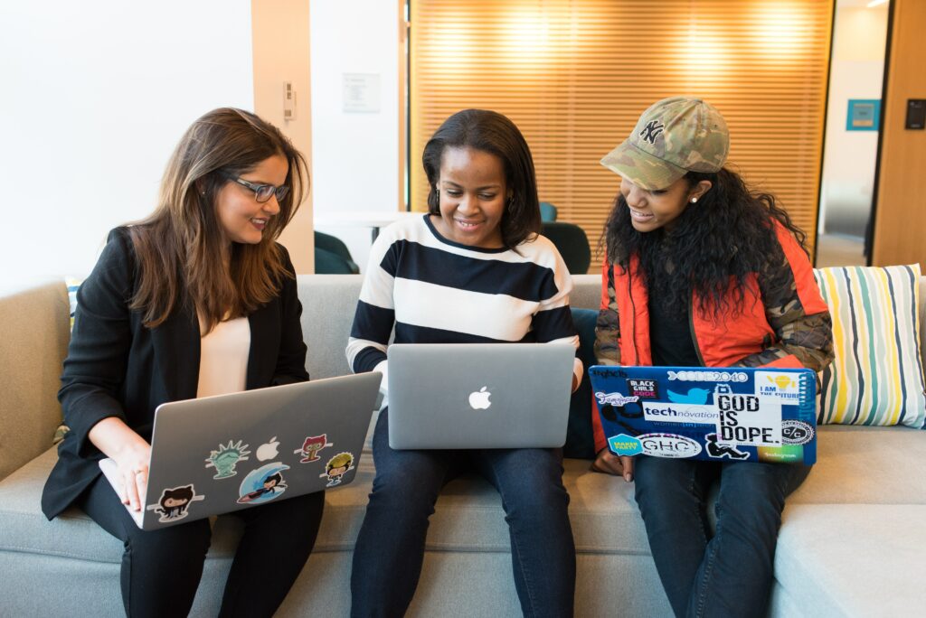 Three women working on laptops in an Austin IT service company.