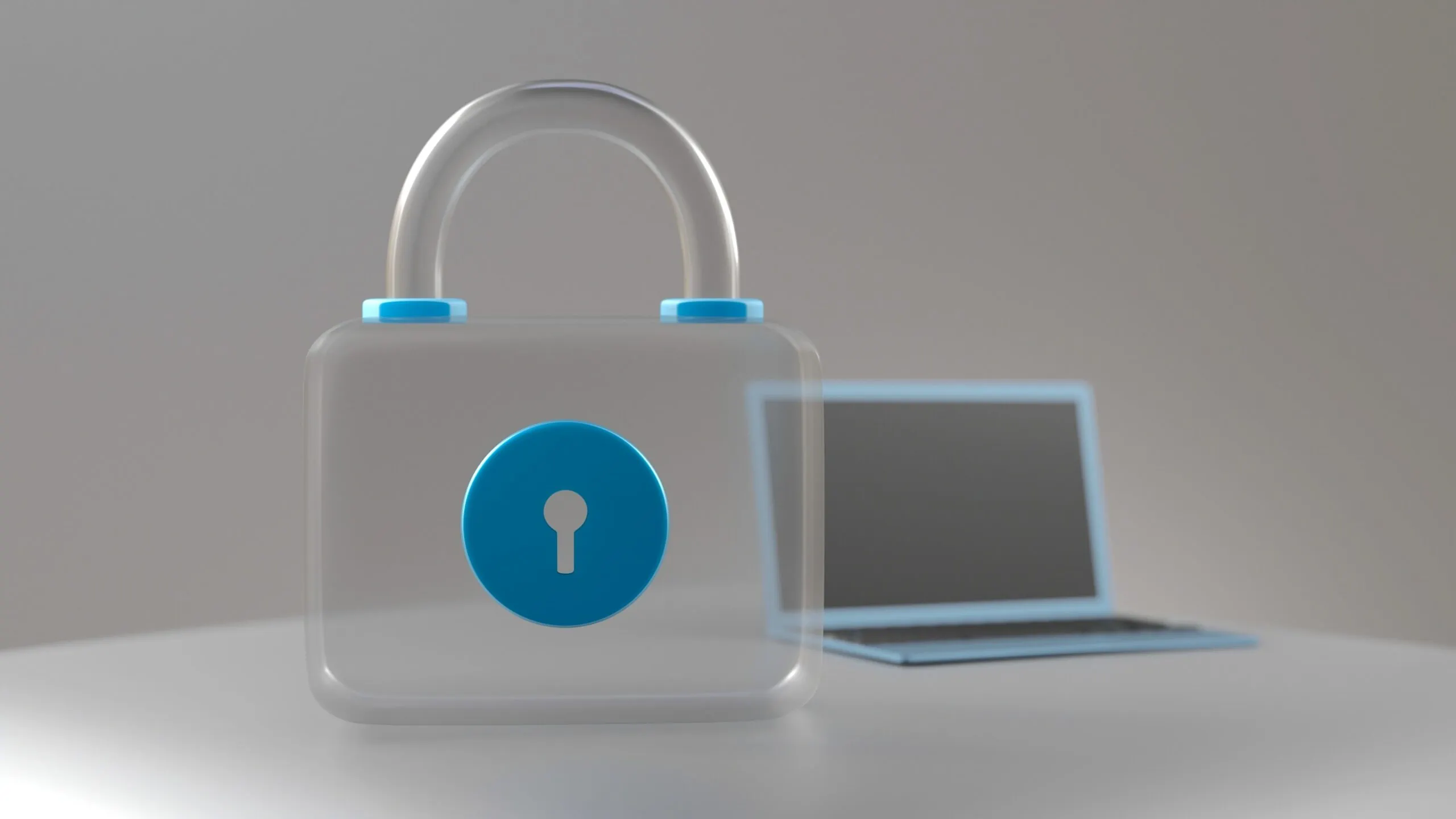 A laptop on a table with a padlock beside it symbolizing the importance of resetting passwords regularly.