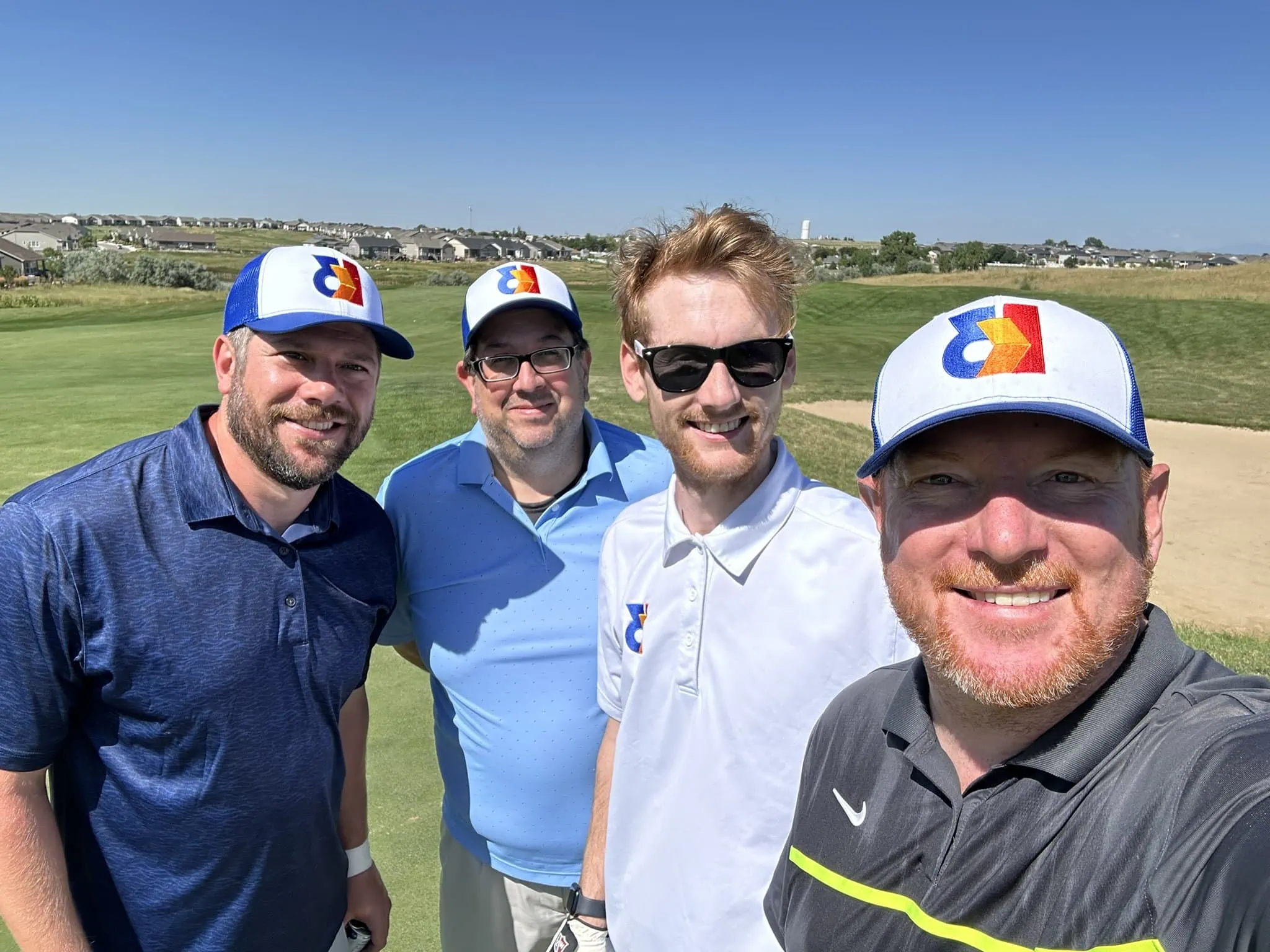 Four men posing for a photo on a golf course, showcasing the reasons to choose K3.