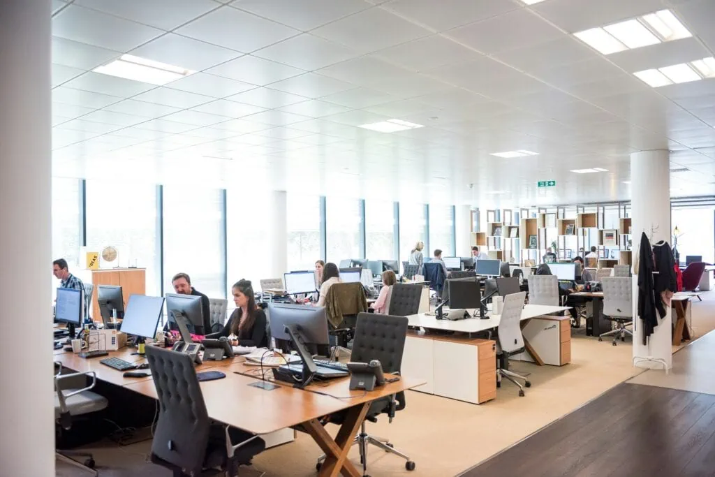 A large open office with many people working at desks, providing remote IT services.