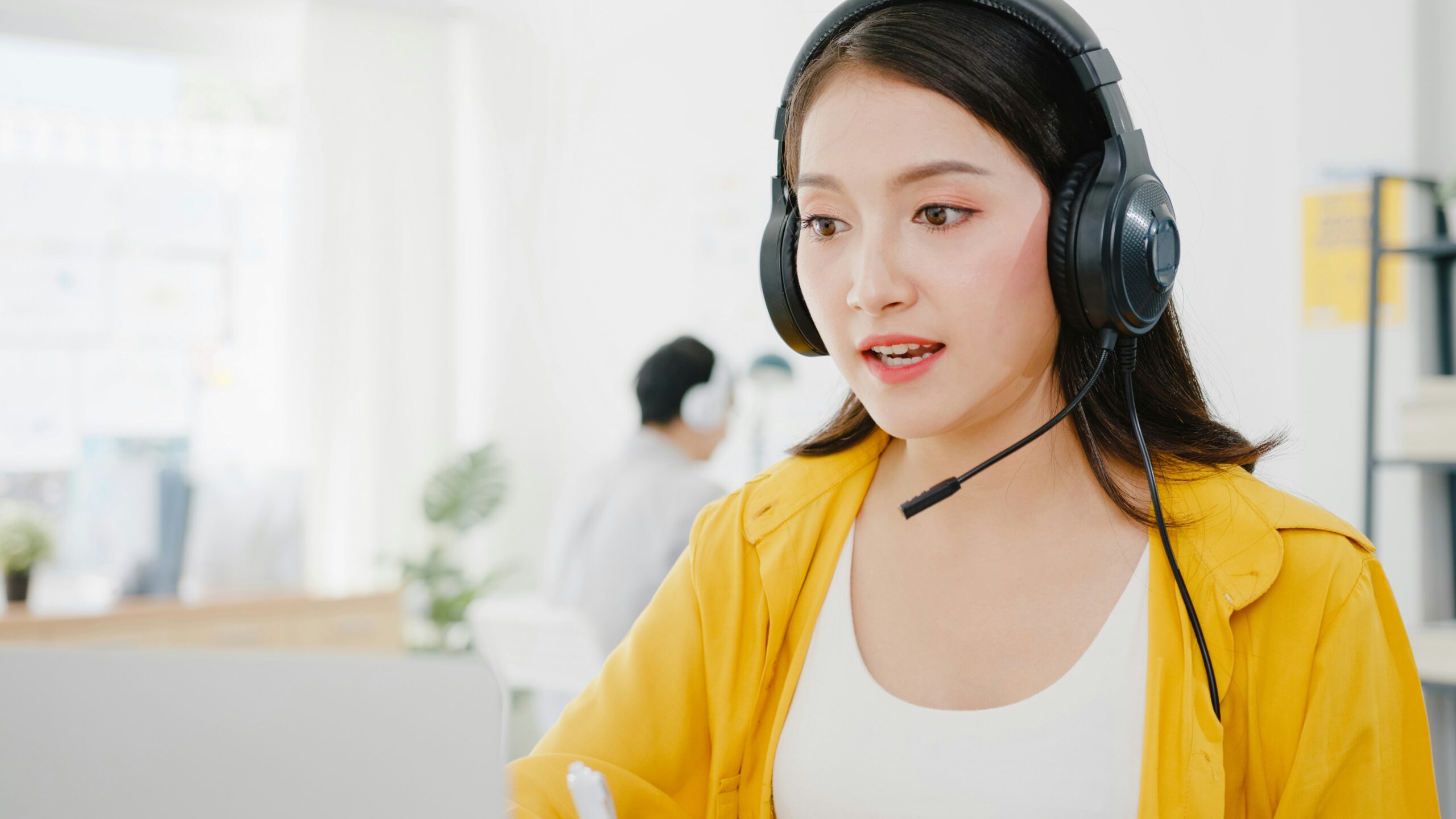 A customer service representative specializing in managed IT, wearing a headset in an office environment.