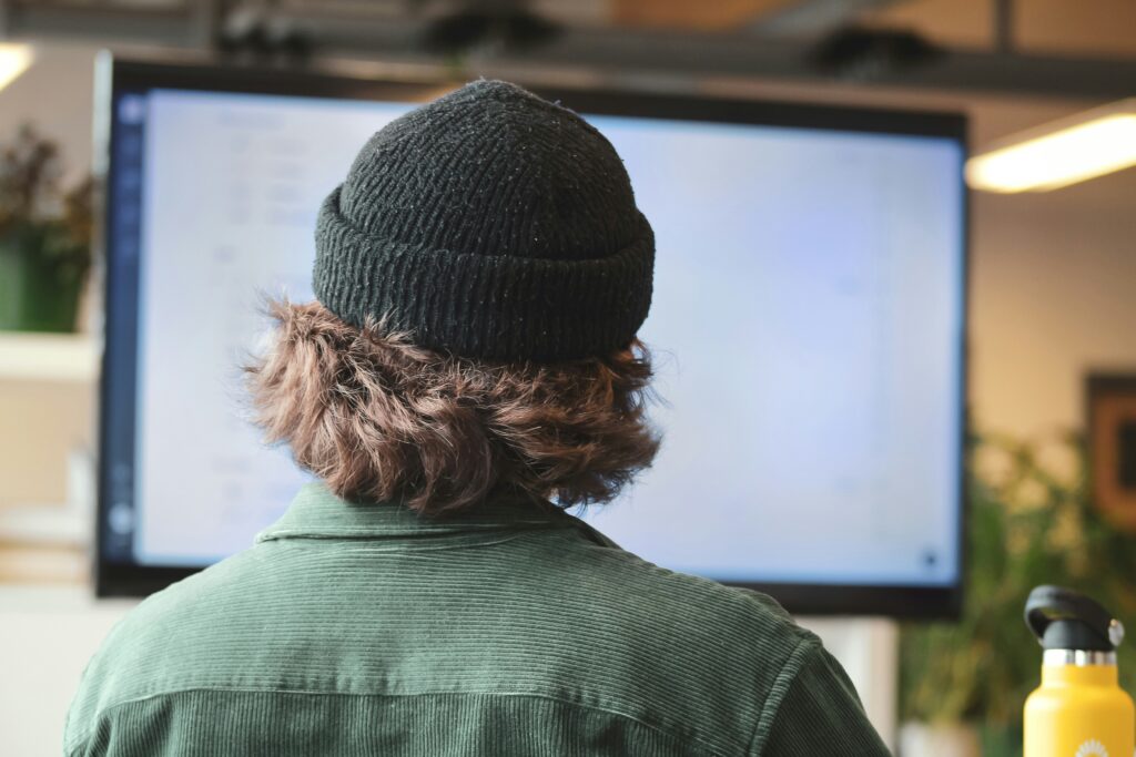 Person wearing a beanie looking at a screen in an MSP cyber security office environment.
