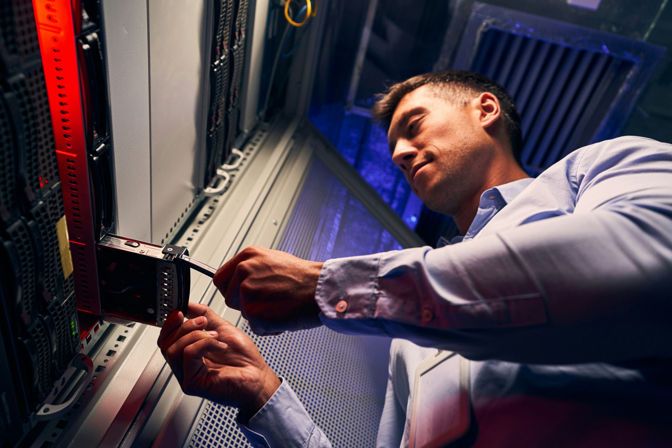A technician working on server hardware in an IT managed services company's data center.