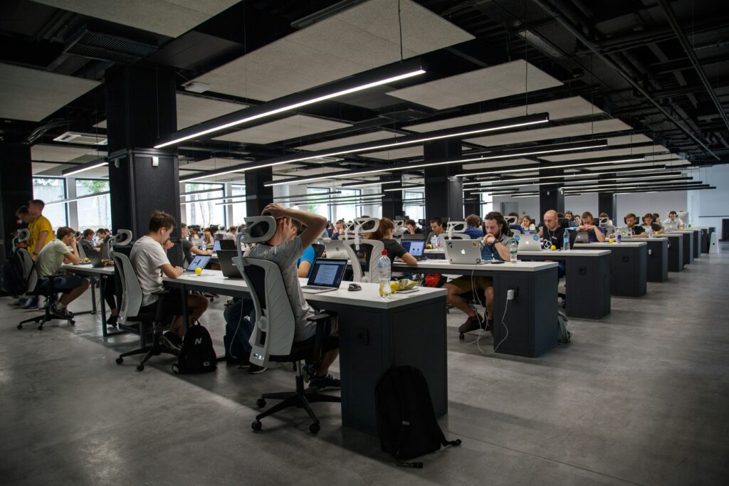A modern office space with numerous individuals working at desks with computers, providing managed IT services for small businesses.